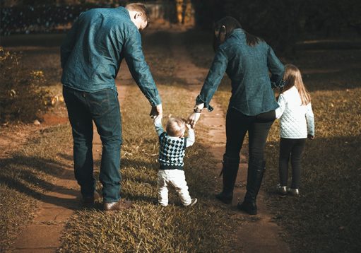 A family walking down a path with their back to the camera